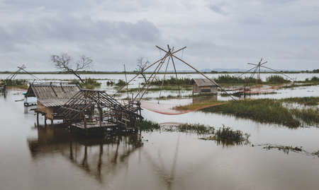 Fisherman cottage in swamp and square dip fish trap with cloudy raining low lighting.の写真素材