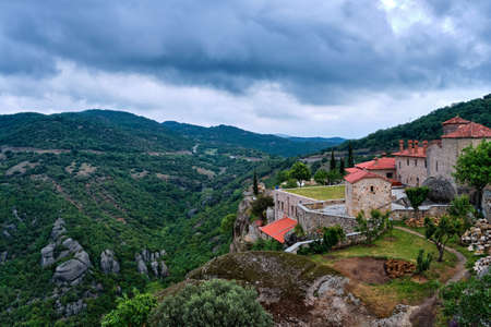 View of clifftop monastery buildings and terrace of Holy Trinity or Agia Triada on rocks of Meteora hills, Greeceの写真素材