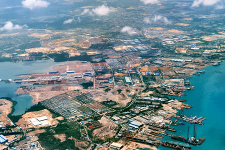 Aerial view of coastal construction or port areas in Strait of Malacca, on airplane route to...