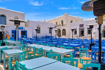 Colorful tables and chairs of Greek outdoor cafes and restaurants on sunny day.