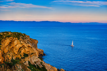 Sailboat navigating in Aegean sea near cape Sounion on sunset, Greeceの写真素材