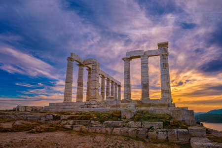 Beautiful sunset sky and ancient ruins of temple of Poseidon, cape Sounio, Aegean sea coast, Greece. Travel destination of Athens area, important center of ancient Greek religion for Olympian Greek mythology, god of the sea and earthquakes,の写真素材