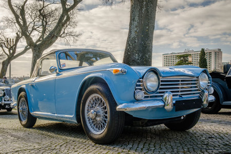 Lisbon, Portugal - Jan 20, 2024: Classic Triumph TR4 car parked on a cobblestone road near park. Light-blue 2-door drophead coupe on sunny dayのeditorial素材