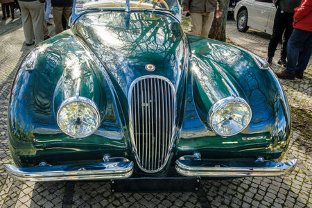 Lisbon, Portugal - Jan 20, 2024: Front view of vintage dark green Jaguar XK120 drophead coupe car parked on cobblestone pavement road. Two-seater roadster, sports car, convertibleのeditorial素材