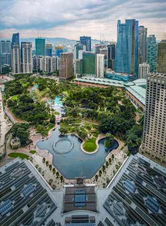Nov 20, 2019 - Kuala Lumpur, Malaysia: Aerial perspective of KLCC Park at day, dramatic sky, landscaped gardens, water fountains, lakes, skyscrapers, green areas, modern city skyline. Urban planning, nature integration, recreation, business centerの写真素材