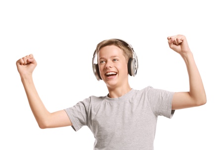Smiling teenage boy listening to music with earphones. Isolated on white backgroundの写真素材