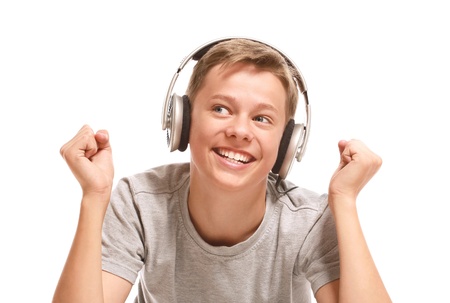 Smiling teenage boy listening to music with earphones. Isolated on white backgroundの写真素材