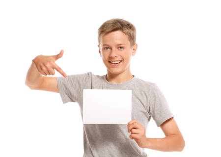 Smiling boy pointing at white blank paper. Isolated on white background の写真素材