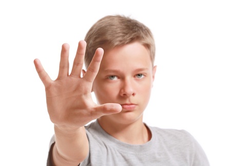 Teenage boy making stop gesture,  isolated on white backgroundの写真素材