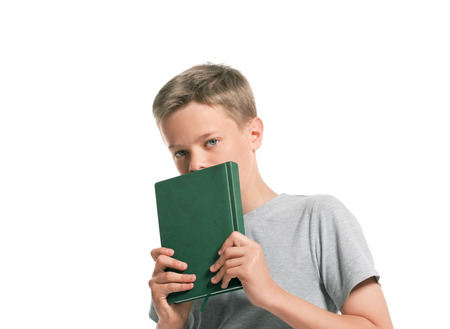 Portrait of thoughtful boy with notepad,  isolated on whiteの写真素材