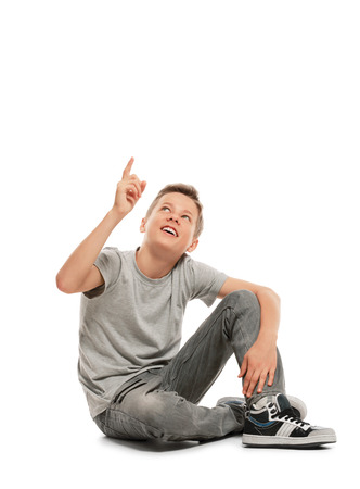 Smiling teenager points up.  Isolated on white backgroundの写真素材