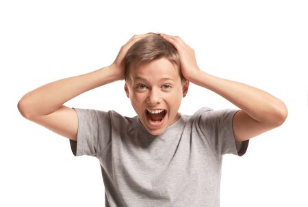 Amazed teenage boy holding his head. Isolated on white backgroundの写真素材