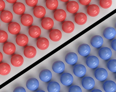 Red and blue spheres separated by a black lineの写真素材