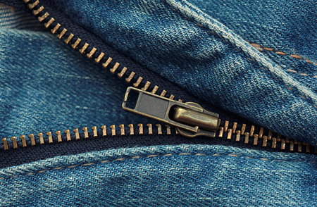 Metal zipper on blue shabby jeansの写真素材