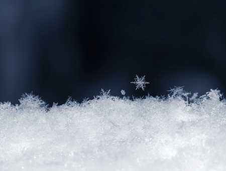 Natural snow with snowflakes on blue background. Winter backgroundの写真素材