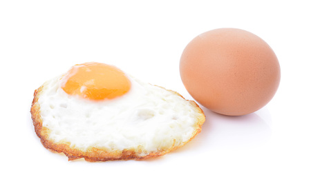 fried egg on white backgroundの写真素材