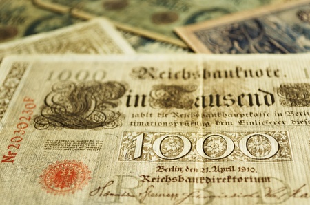 Part of an old German banknote from 1910. Other old banknotes can be seen blurred in the background.の写真素材