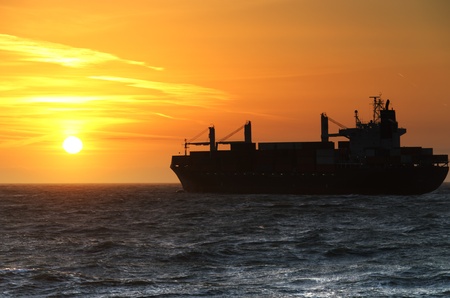 Container Ship cruising into the sunset on the North Sea の写真素材