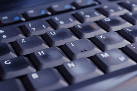 A black keyboard illuminated by the computer screen  Selective Focus 