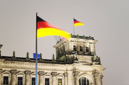 German flag waving above the Reichstag, the german parliament in Berlin の写真素材