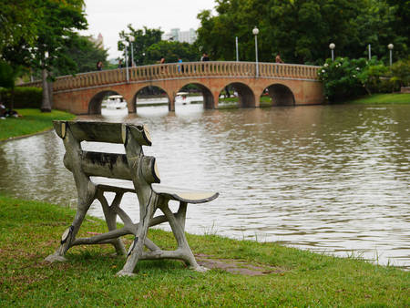 Bench beside the lake at the park in Thailandの写真素材
