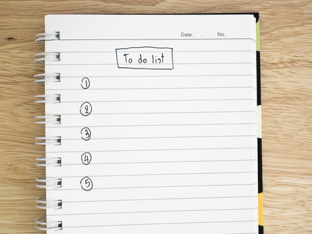 To do list on notebook with wood background
