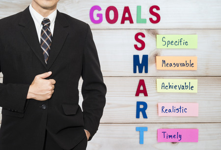 One business man  wear black suit stand on SMART Goal in wood background (Business Concept)の写真素材