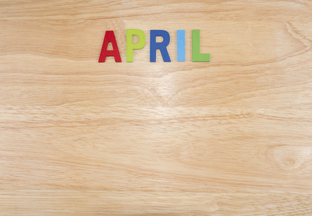 Word spelling month in the year "April" by wooden letters on wood background (Month name word series)の写真素材