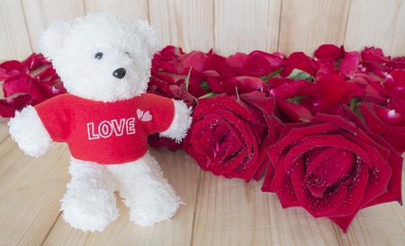 Red rose flower and teddy bear on wood background, Love concept for Valentines Dayの写真素材