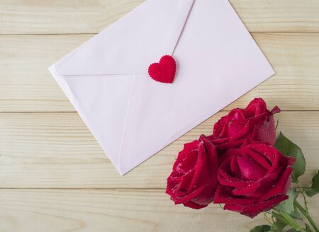 Red rose and pink envelope in love concept on wood background, Valentines day