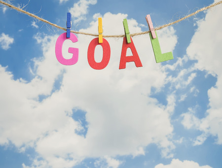 Word Goal by wooden letters hang with rope on blue sky background (Business Concept)