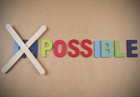 Wooden word impossible transformed into possible. Motivation with business conceptの写真素材