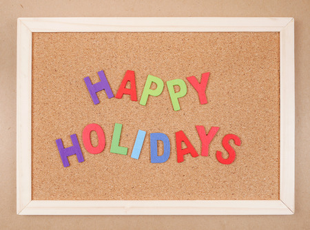 Word spelling "Happy Holidays" on cork board (Business concept)の写真素材