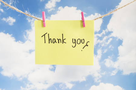 Word "Thank you" on colorful note paper with blue sky backgroundの写真素材