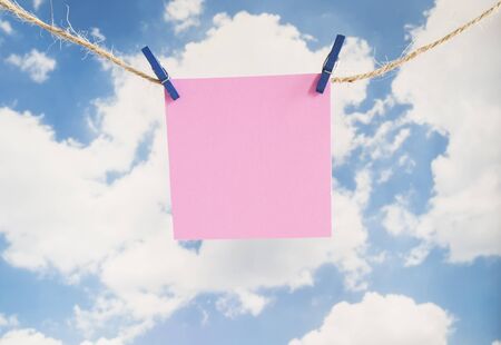 One empty note paper hang with rope on wood backgroundの写真素材