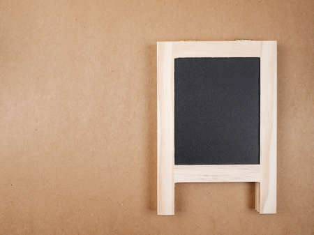 Blank black board on brown paper backgroundの写真素材
