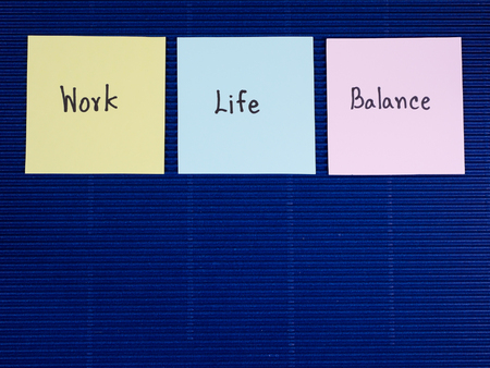 Word "Work Life Balance" on colorful note paper with blue paper backgroundの写真素材