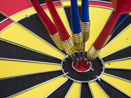 Dart arrows pin in the center of dart board (Business Concept)