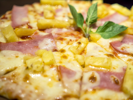 Closeup Hawaiian pizza on dish in the restaurant (Selective focus)の写真素材