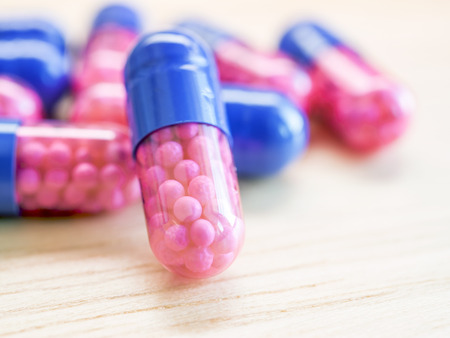 Closeup group of blue - pink capsule medicine, pharmaceutical theme (Selective focus)