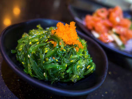 Closeup seaweed salad on black bowl in the restaurant (Selective Focus)の写真素材