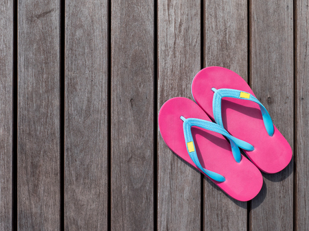 Pink flip flop  pink slipper on wooden floor on top view with sunlight in the afternoonの写真素材