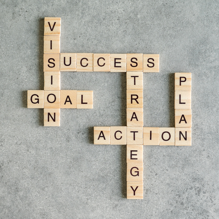 Wooden cubes crossword of Success, Vision, Mission, Goal, Action on wood background