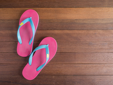 Pink flip flop / pink slipper on wooden floor on top viewの写真素材