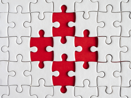 Three white jigsaw puzzle on red background in top view (Business Concept)の写真素材