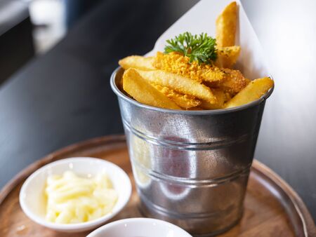 Selective focus of french fries on wooden dish in the restaurantの写真素材