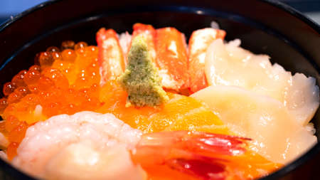 Selective focus of mix sashimi (salmon, crab, shrimp, scallop) in rice bowl, mix sushi donburi in the restaurant (Japanese food)の写真素材