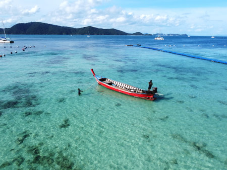 Phuket island seaside, Thailand. Beautiful clear green blue coast with blue cloudy sky. Local sailboat. Aerial view : 12 October 2020 - Phuket island, Thailand.のeditorial素材