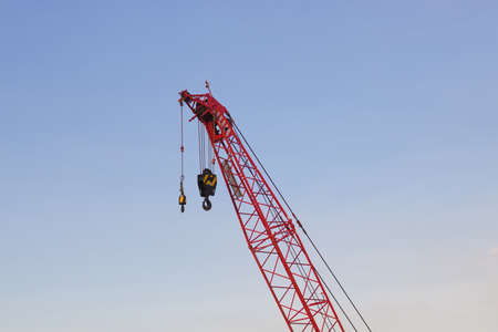 Red high crane at construction site with blue sky sunset background.の写真素材