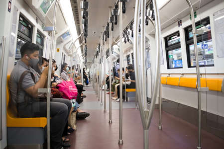 Bangkok, Thailand - February 3, 2021 : Passenger taking sky train (BTS) wearing face mask, and distancing during Corona Virus Disease (COVID-19). Concept new normal.のeditorial素材